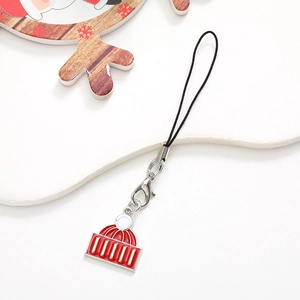 Detailed view of red Christmas house metal charm with silver clasp on a black lanyard