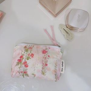 Detail of floral cotton pouch showing pink flower pattern and white zipper with cord
