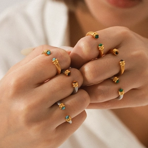 Gros plan de bagues torsadées avec des pierres précieuses malachite et turquoise