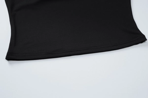 Détail de l'ourlet à double couture sur une mini-jupe noire en tissu élastique