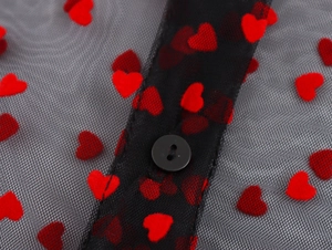 Detail of red flocked heart patterns on black mesh fabric with a small black button