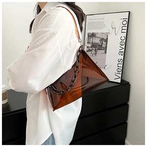 Detail of a brown transparent jelly bag with a chunky thick chain strap on model