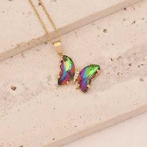 Détail du pendentif papillon dégradé avec ailes irisées et cristaux sur chaîne dorée