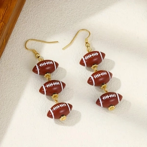 Long beaded earrings featuring brown acrylic footballs with golden hooks and white details