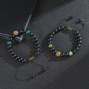 Adjustable tiger eye beaded bracelet set with gold zircon hollow balls on black background
