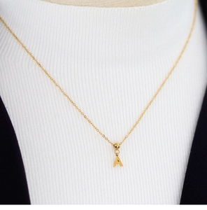 Detail of adjustable gold necklace with letter A pendant on a professional model