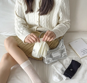 Détail de chaussettes mi-mollet en coton blanc avec broderie délicate style ballerine