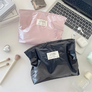 Glossy silver finish makeup bags in pink and black with minimalist woven label detail