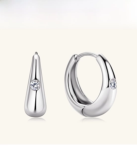 Macro view of sterling silver hoop earrings with teardrop design and central moissanite