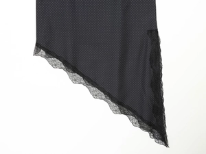 Détail de haut à pois avec bordure en dentelle noire et ourlet asymétrique
