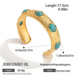 Detail of 18K gold-plated stainless steel cuff with hammered texture and turquoise accents