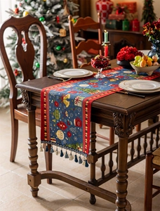 Blue Christmas table runner with red tassels and festive holiday pattern details