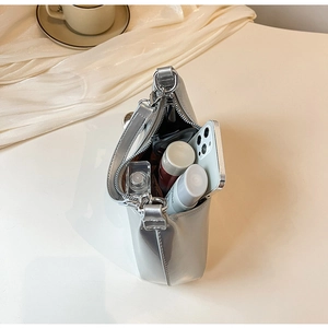 Internal space view of silver glossy dumpling bag with phone and cosmetics layout