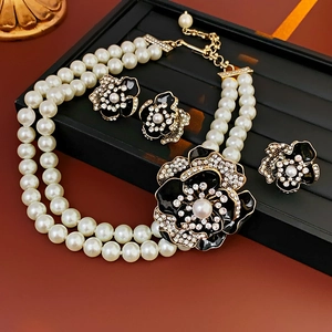 Detailed view of vintage double-layer pearl necklace with black enamel floral pendant