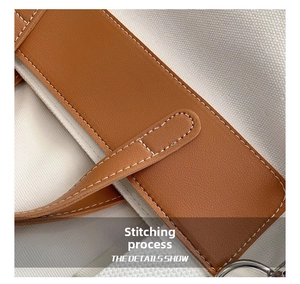 Detail show of canvas tote bag featuring premium brown leather trim and white stitching