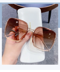 Detail of square oversized sunglasses with brown gradient lenses and champagne frames
