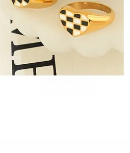 Detail view of heart-shaped ring featuring black and white checkerboard pattern on gold band