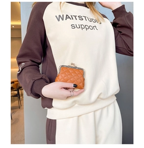 Detailansicht einer orangebraunen gesteppten PU-Leder Geldbörse mit Vintage-Gold-Metallverschluss