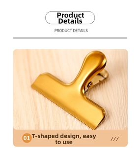 Close-up of golden T-shape stainless steel food clip with brushed metal finish
