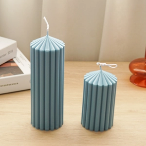 Detailed close-up of blue textured cylindrical candles on a wooden table with home decor
