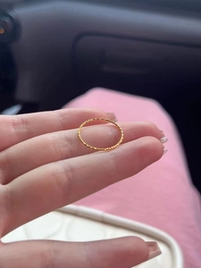 Close-up of a slim gold titanium steel ring with sparkling stardust texture details
