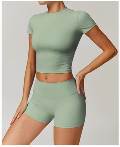 Detail of sage green yoga set showing high-waist shorts and cropped short sleeve top