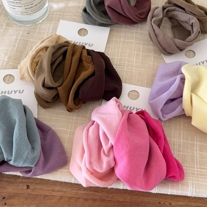 Close-up of soft seamless elastic hair ties in assorted colors on linen background