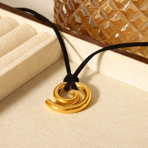Macro view of 18K gold spiral pendant necklace with a minimalist black velvet cord