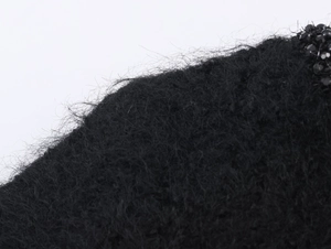 Close-up of black fluffy mohair knitwear with detailed beadwork and sequins