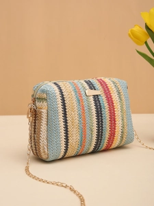 Detail of colorful woven camera bag with golden chain strap and rainbow stripes