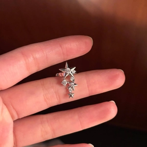 Silver star ear cuff with sparkling zircon stones held by hand to show compact size