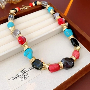 Detail of vintage necklace with colorful irregular stones and gold metal spacers