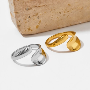 Minimalist irregular open stainless steel rings in gold and silver on stone prop