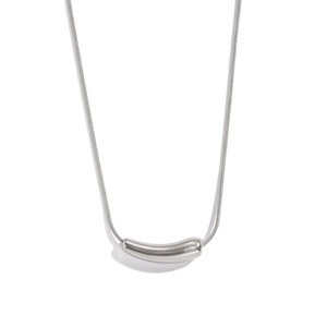 Macro detail of a polished curved pendant on a fine snake chain necklace for women