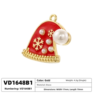 Detailed view of brass Christmas hat pendant with gold snowflake embossing and faux pearls