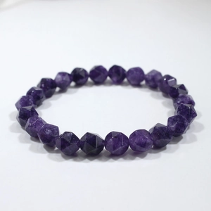 Detailed macro view of multifaceted deep purple crystal beads on an elastic bracelet