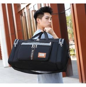 Large black Oxford travel bag with gray trim carried by model in outdoor city setting