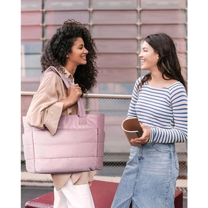 Pink quilted tote bag on shoulder shown in casual outdoor lifestyle setting