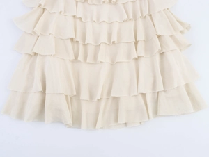 Close-up of cream layered ruffle skirt detailing lightweight textured chiffon fabric