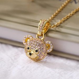 18K gold plated necklace with bear pendant featuring purple zircon stones on white fabric