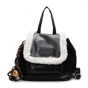 Suede sheepskin patchwork backpack in black and white with a gold bell charm
