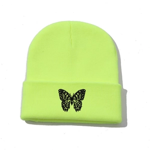Close-up of butterfly embroidery detail on the neon yellow ribbed knit beanie hat