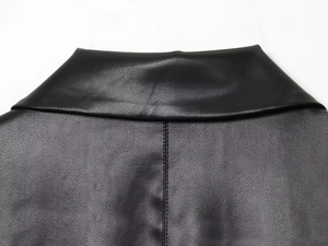 Detailed view of collar and back seam stitching on black faux leather blazer