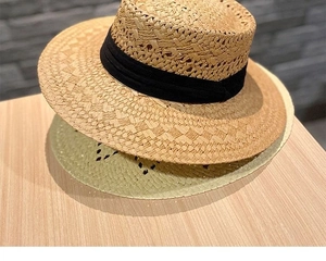 Details der feinen Strohflecht-Textur und elegantes breites schwarzes Band am Sommerhut