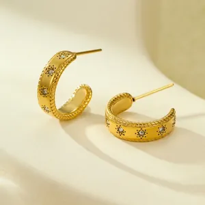 Detailed close-up of 18K gold-plated geometric hoop earrings with star-set cubic zirconia