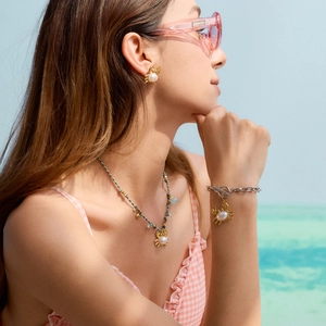 Parure de bijoux en acier doré 18 carats avec pendentifs crabe et perles portés à la plage