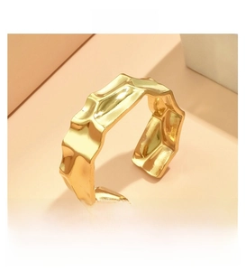 Close-up of golden irregular crumpled texture and hammered finish on stainless steel ring