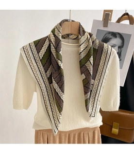 Fashionable square silk scarf with geometric weave pattern styled as a shawl over a white knit