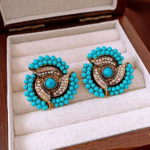 Vintage gold studs with turquoise beads and floral crystals in a luxury jewelry box