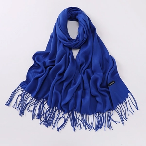 Detailed macro view of soft blue cashmere scarf texture with elegant fringed edges